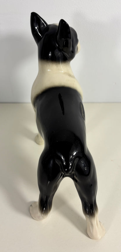 Black and white ceramic dog figurine on a plain background