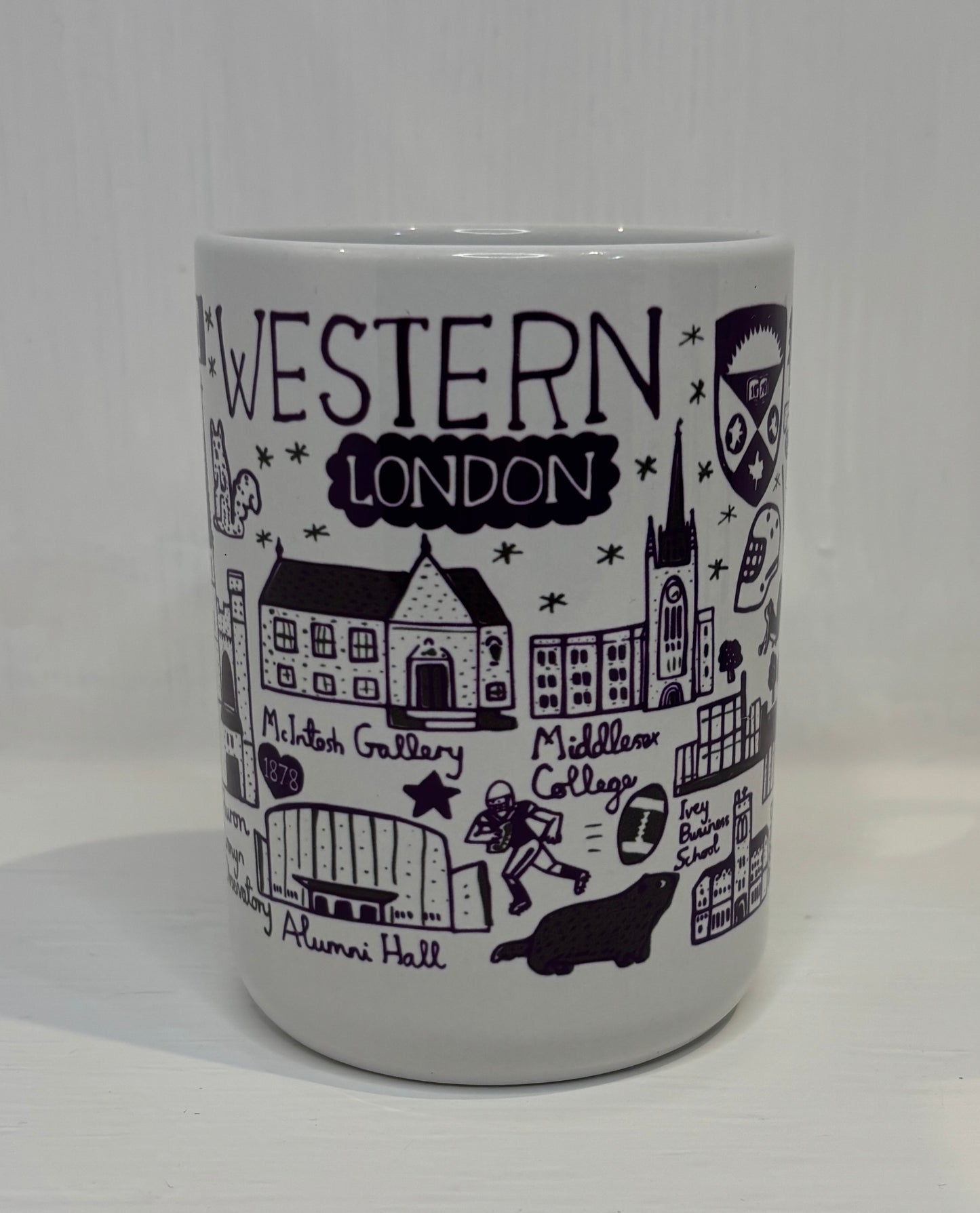 White mug with black illustrations and text of Western London institutions on a white background