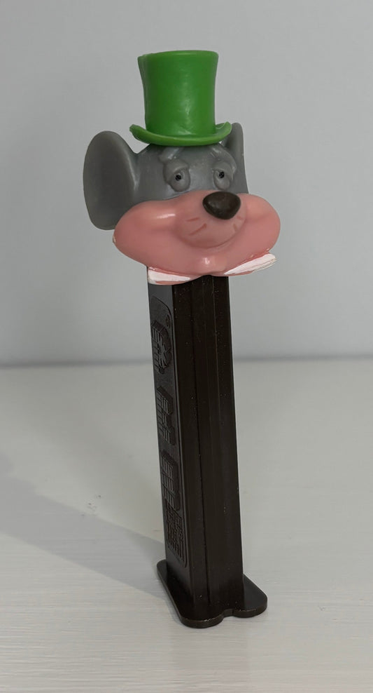 Toy figure of a character with a green top hat and pink nose on a white background