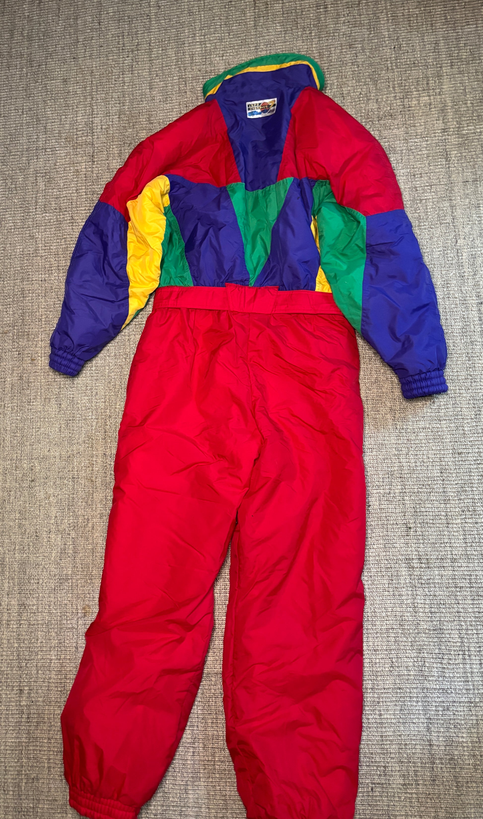 Colorful snowsuit with red base on a textured surface