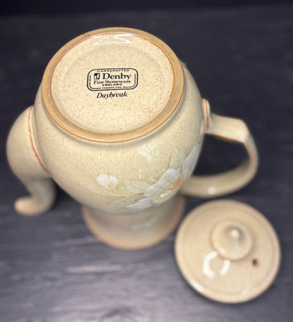 Ceramic teapot with 'Denby' branding on a dark background