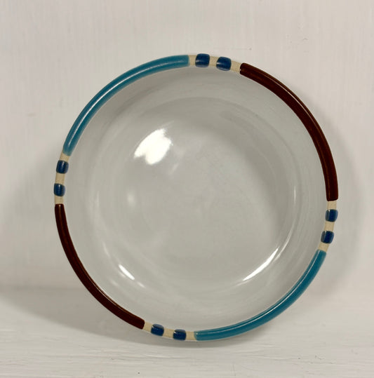 Ceramic bowl with blue and brown rim on a white background