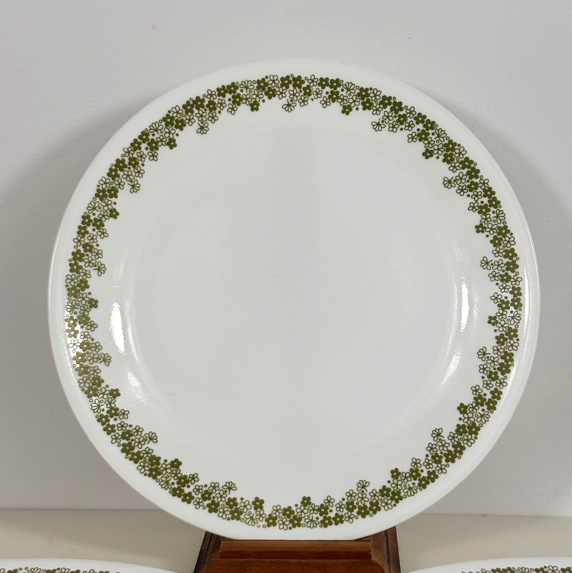 White plate with green floral pattern on a white background