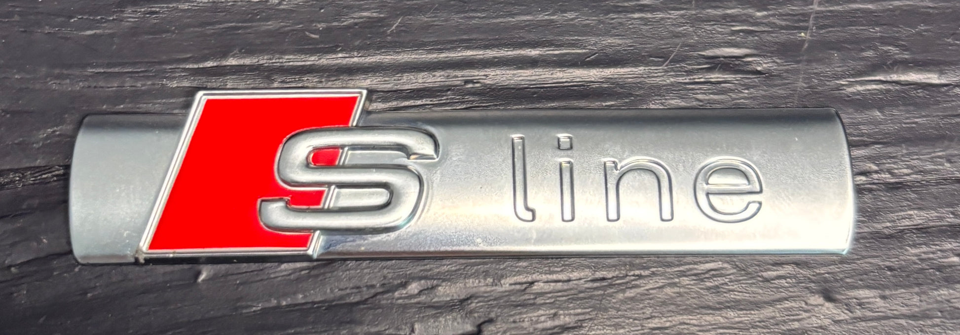 Audi S line badge on a dark surface