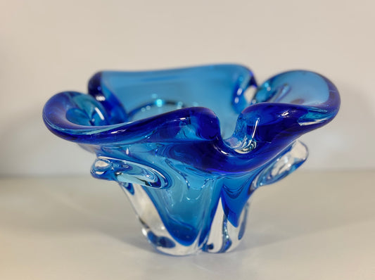 Blue glass bowl with wavy design on a light background