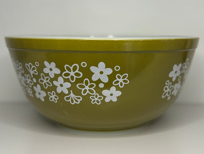 Green bowl with white floral pattern on a white background