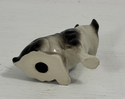 Small ceramic figurine of a dog on a white background
