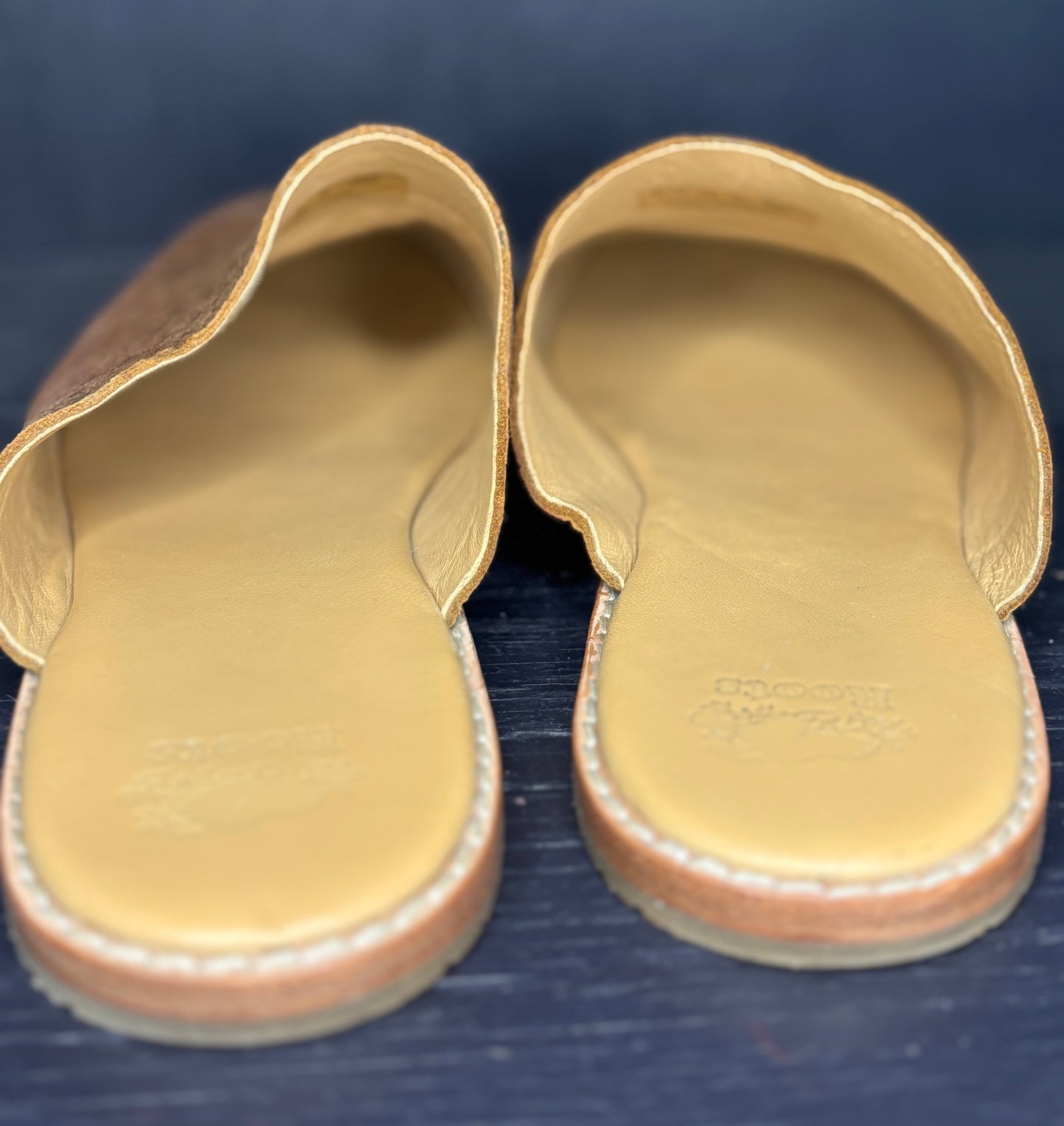 Pair of sandals with visible brand name on a dark background