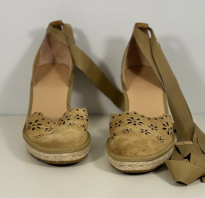 Pair of tan wedge sandals with strap on a white background