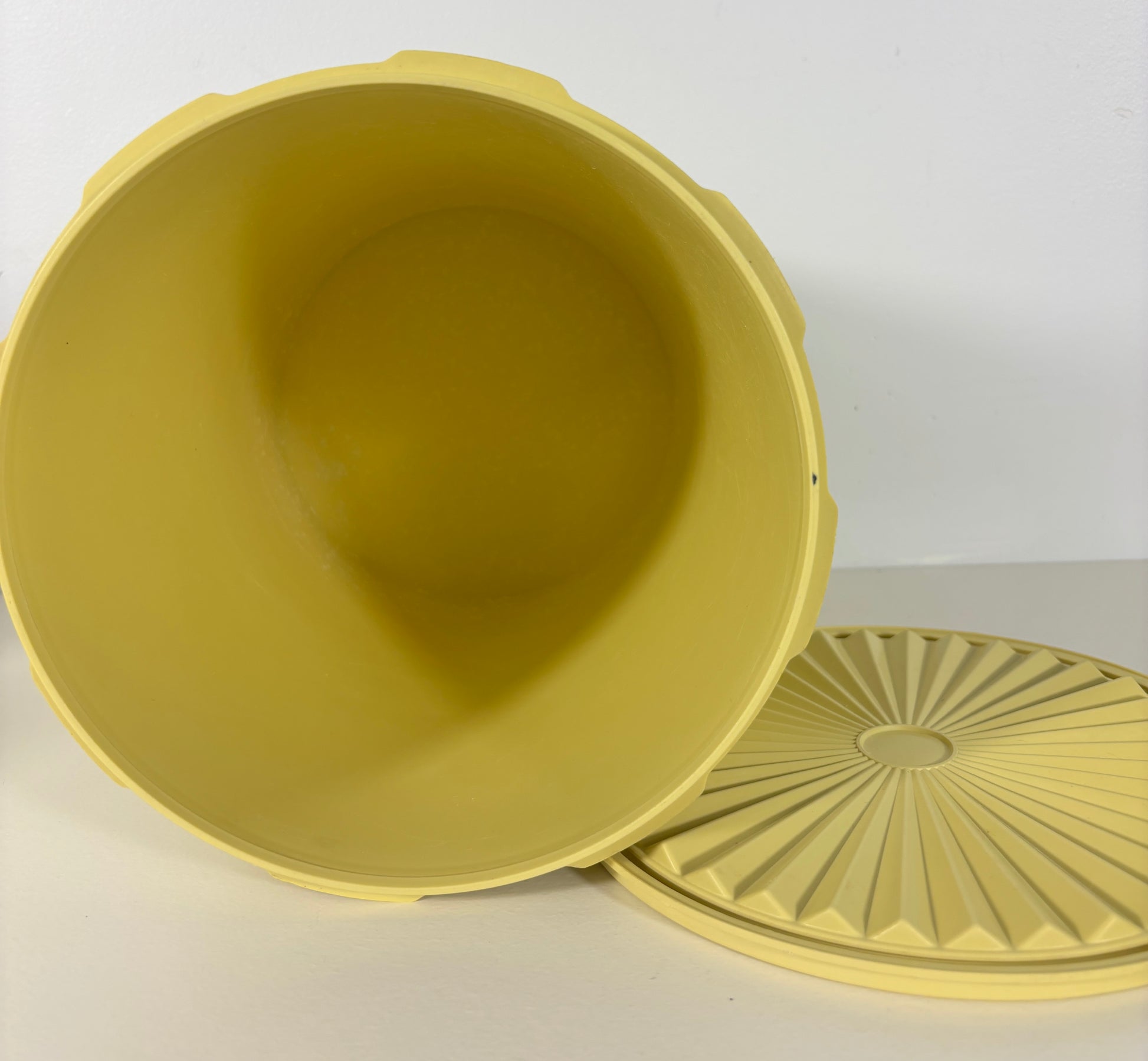 Yellow plastic container with lid on a white background