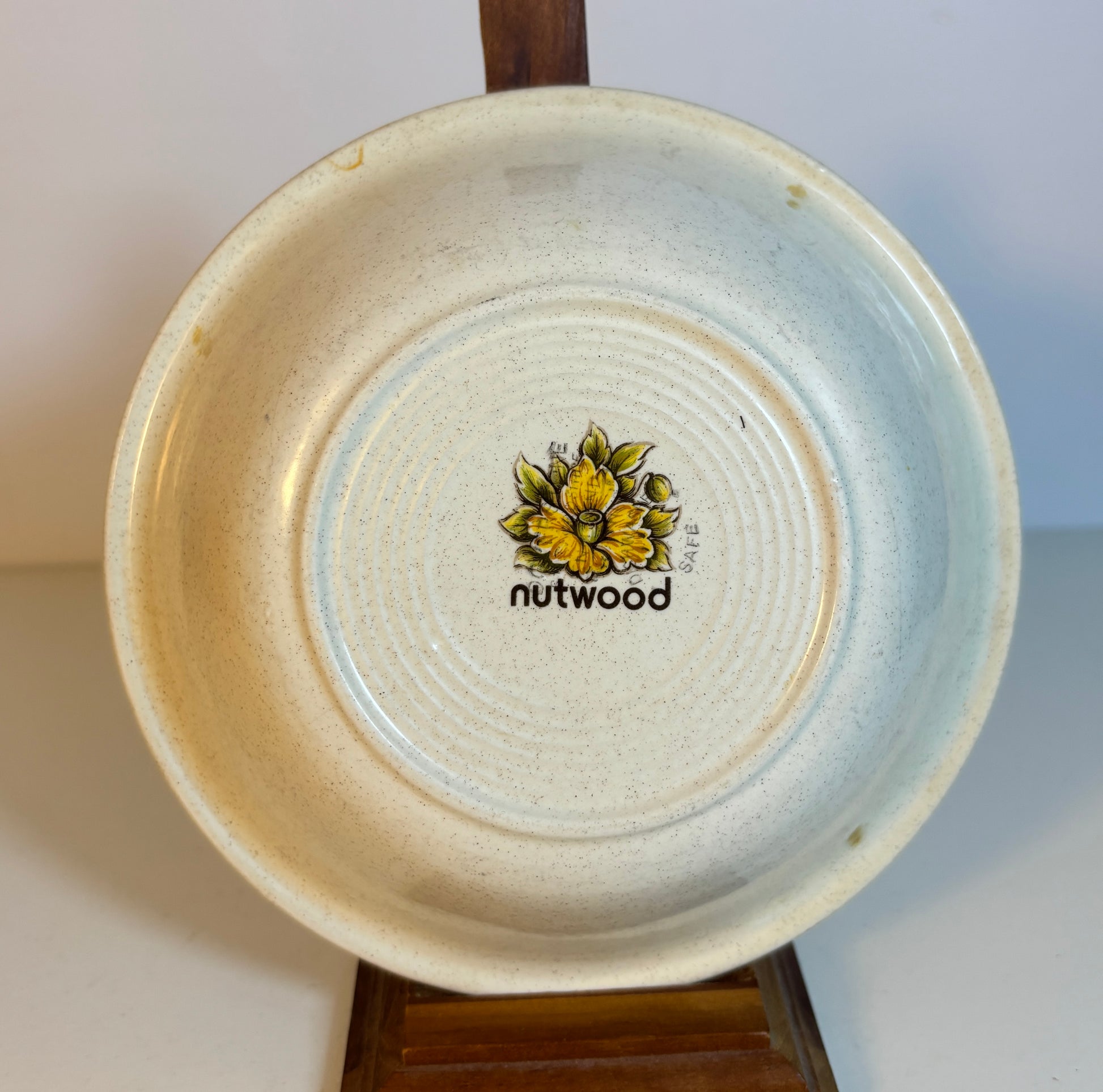 Ceramic plate with a floral design and 'nutwood' branding on a white background