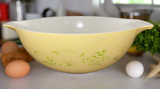 yello Pyrex bowl with green flowers, leaves, stem, vines