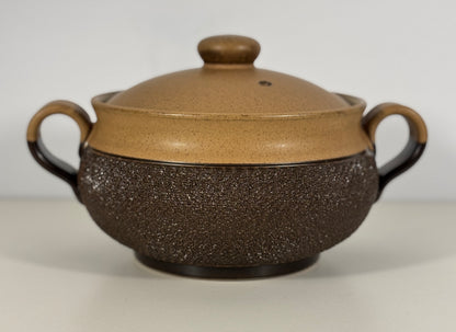 Brown ceramic pot with textured surface on a white background