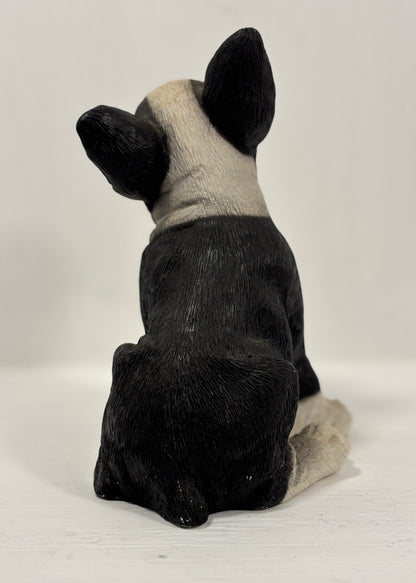 Black and white dog figurine sitting on a white background