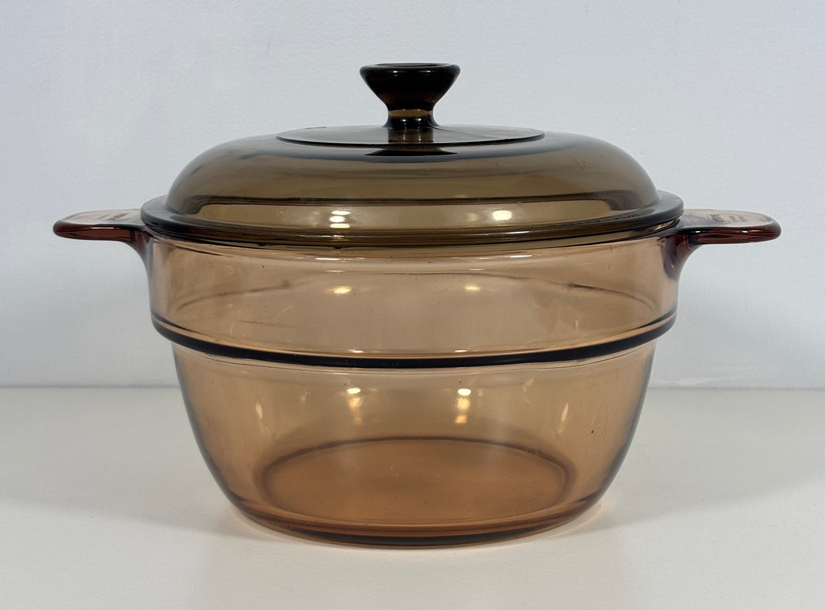 A translucent amber-brown glass casserole dish with a matching lid, shown on a plain white background.
