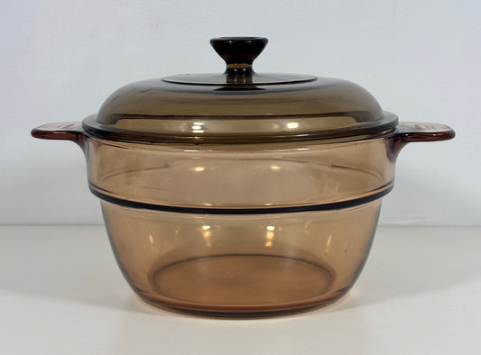 A translucent amber-brown glass casserole dish with a matching lid, shown on a plain white background.