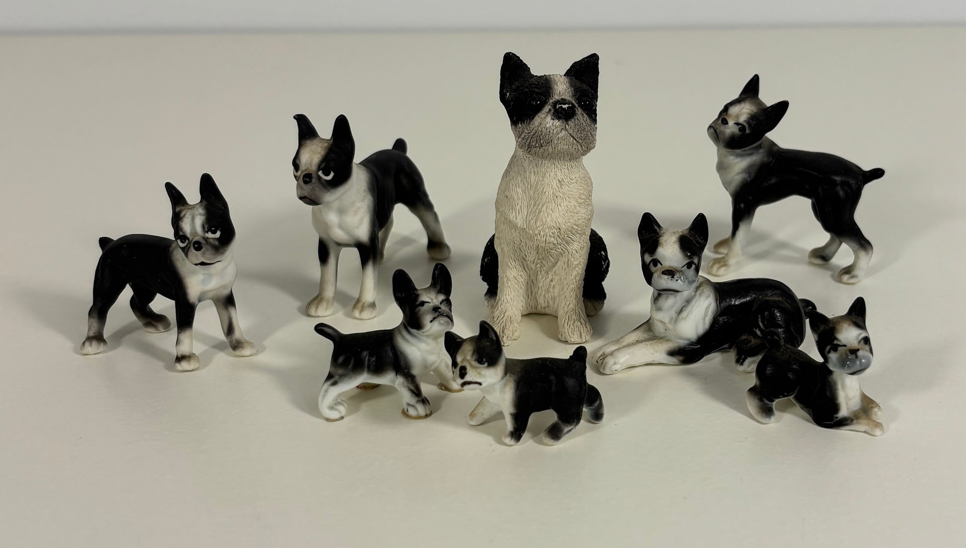 Collection of black and white dog figurines on a light gray background