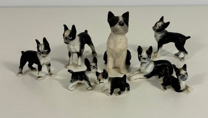 Collection of black and white dog figurines on a light gray background