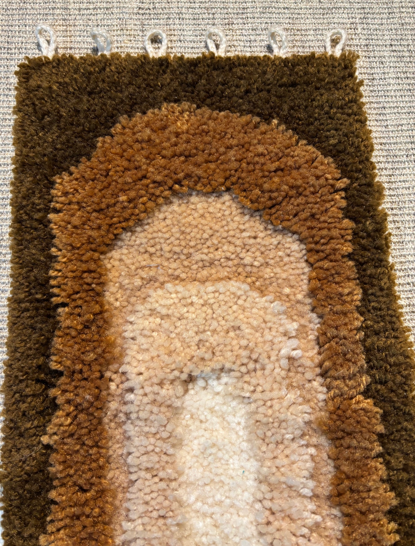 Close-up of a textured brown and beige rug with a pattern.