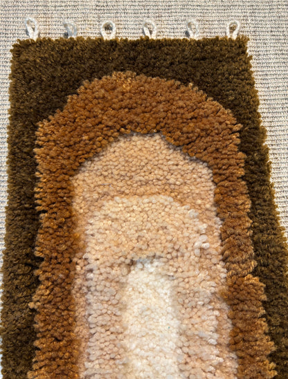 Close-up of a textured brown and beige rug with a pattern.