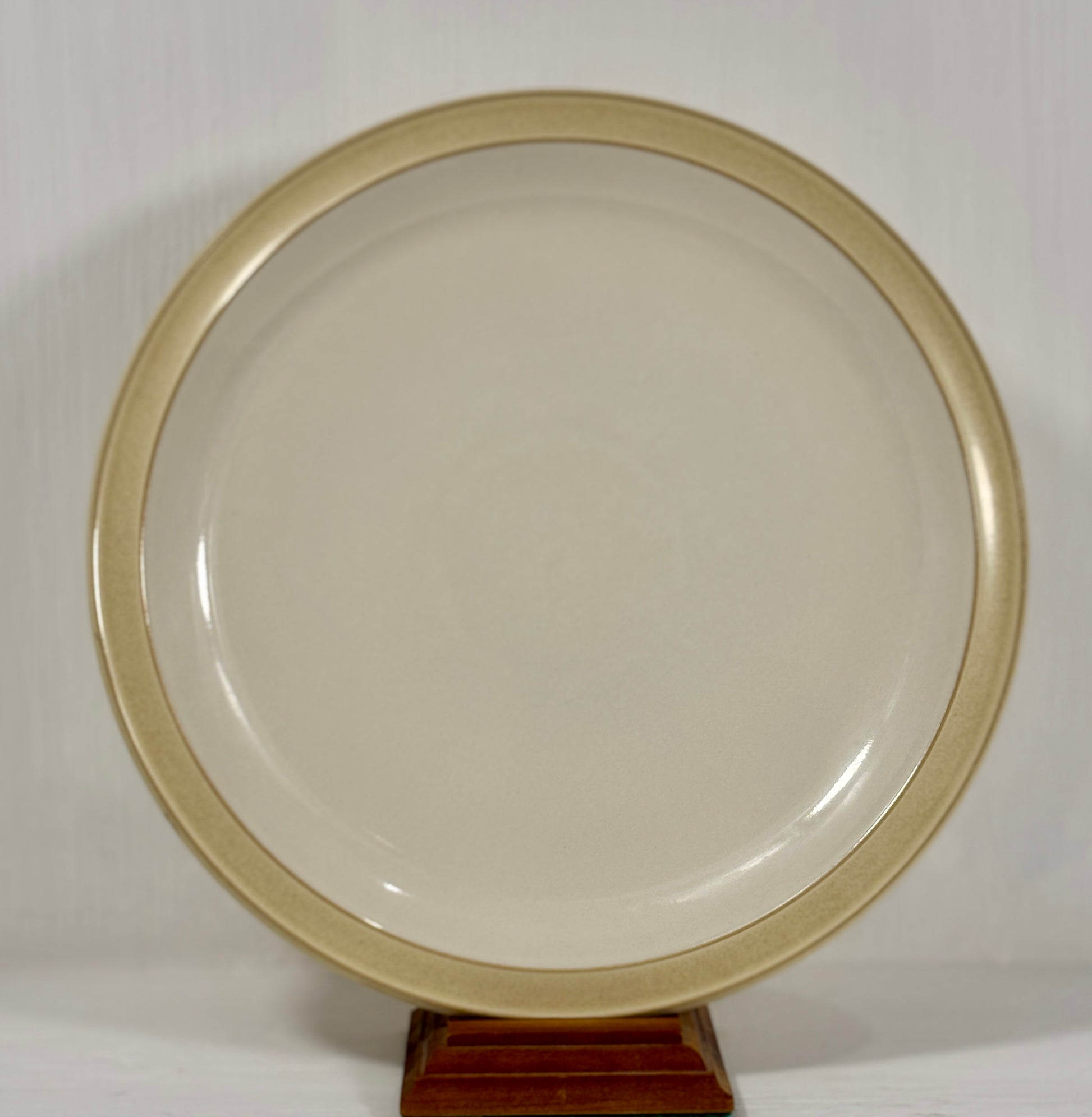 Round beige object on a stand against a white background