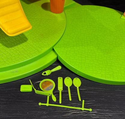 Green play mat with accessories on a dark surface