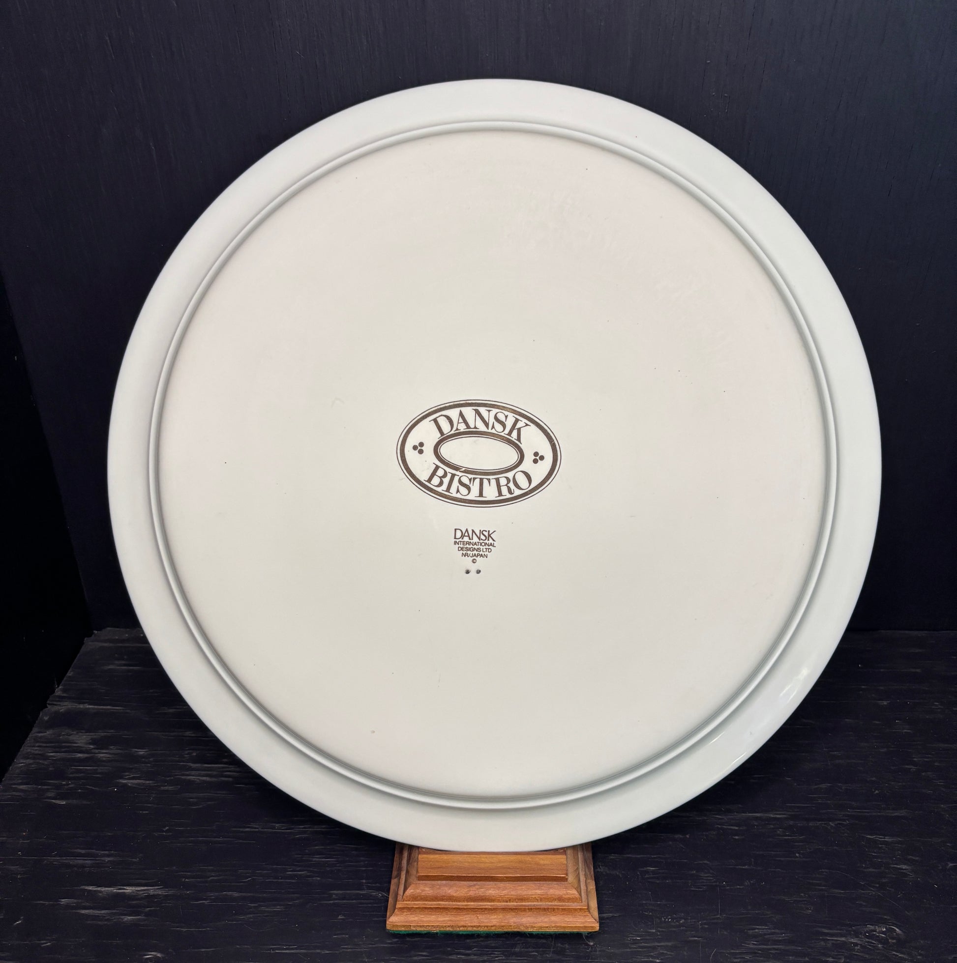 White plate with 'Dansk Bistro' logo on a dark background