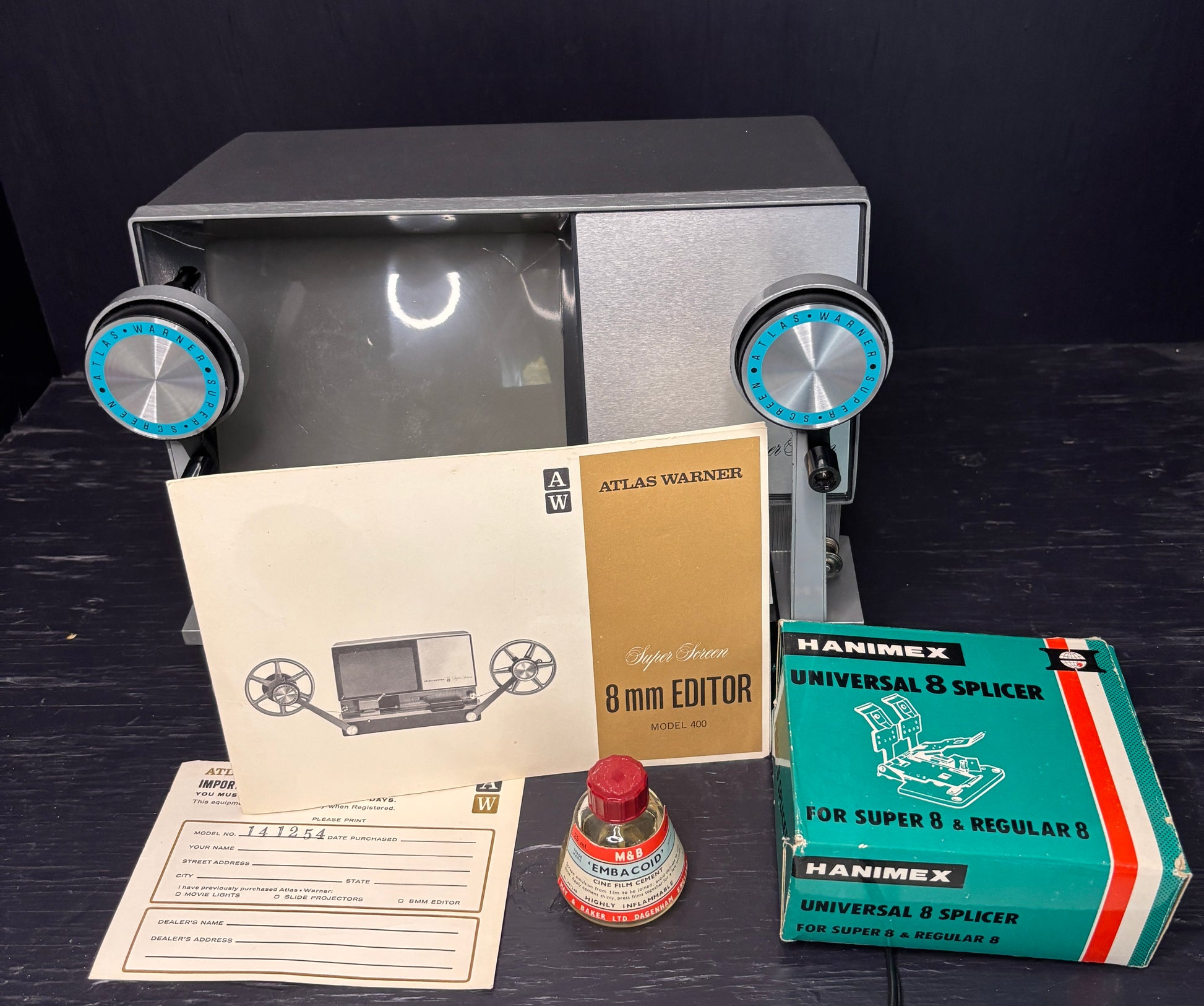 Vintage 8mm film editor with accessories on a dark surface