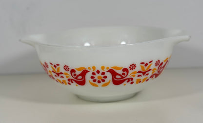White bowl with red and orange floral and bird pattern on a white background