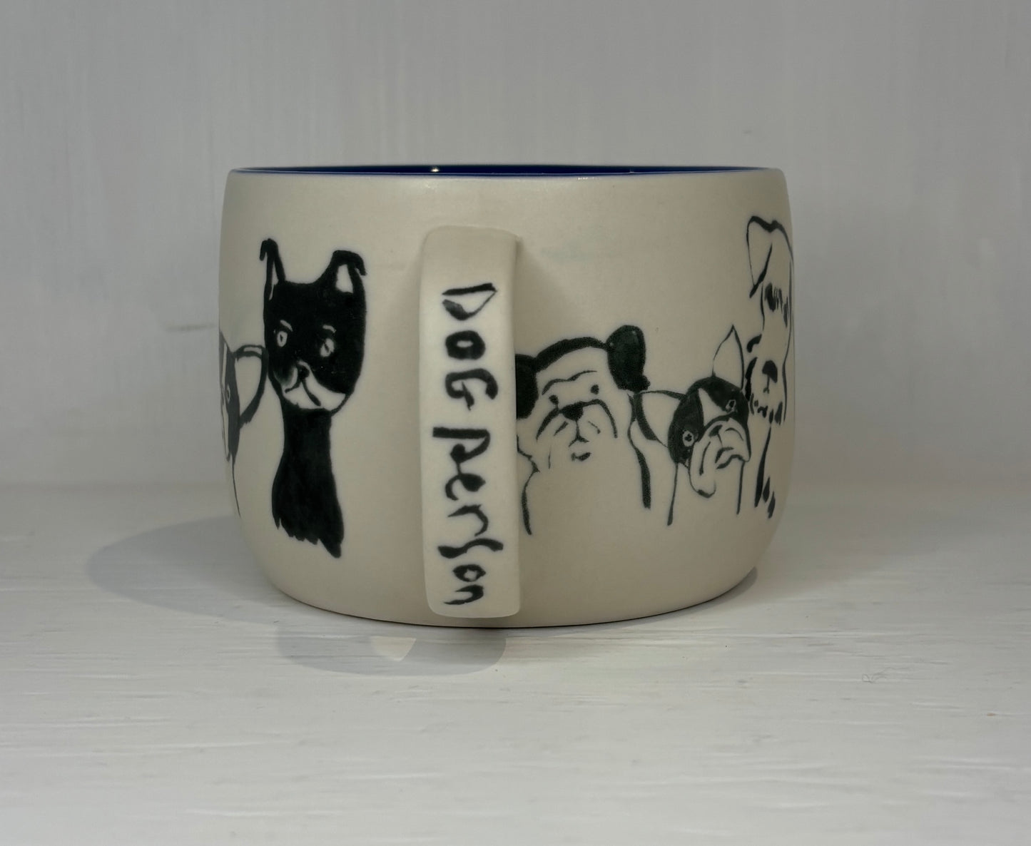 Ceramic mug with dog illustrations and 'Dog Person' text on a white background