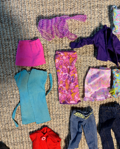 Collection of colorful doll clothes on a textured surface