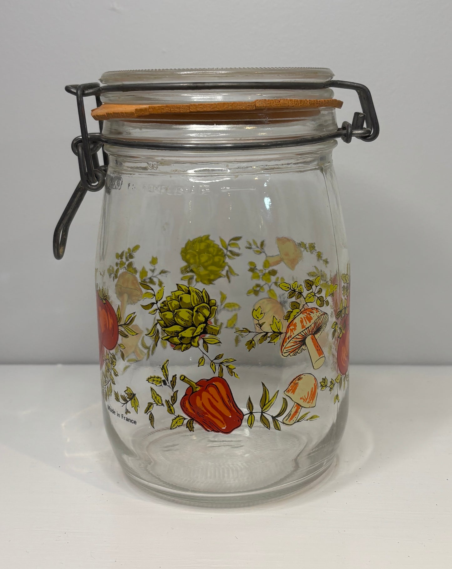 Glass jar with floral and mushroom design on a white background