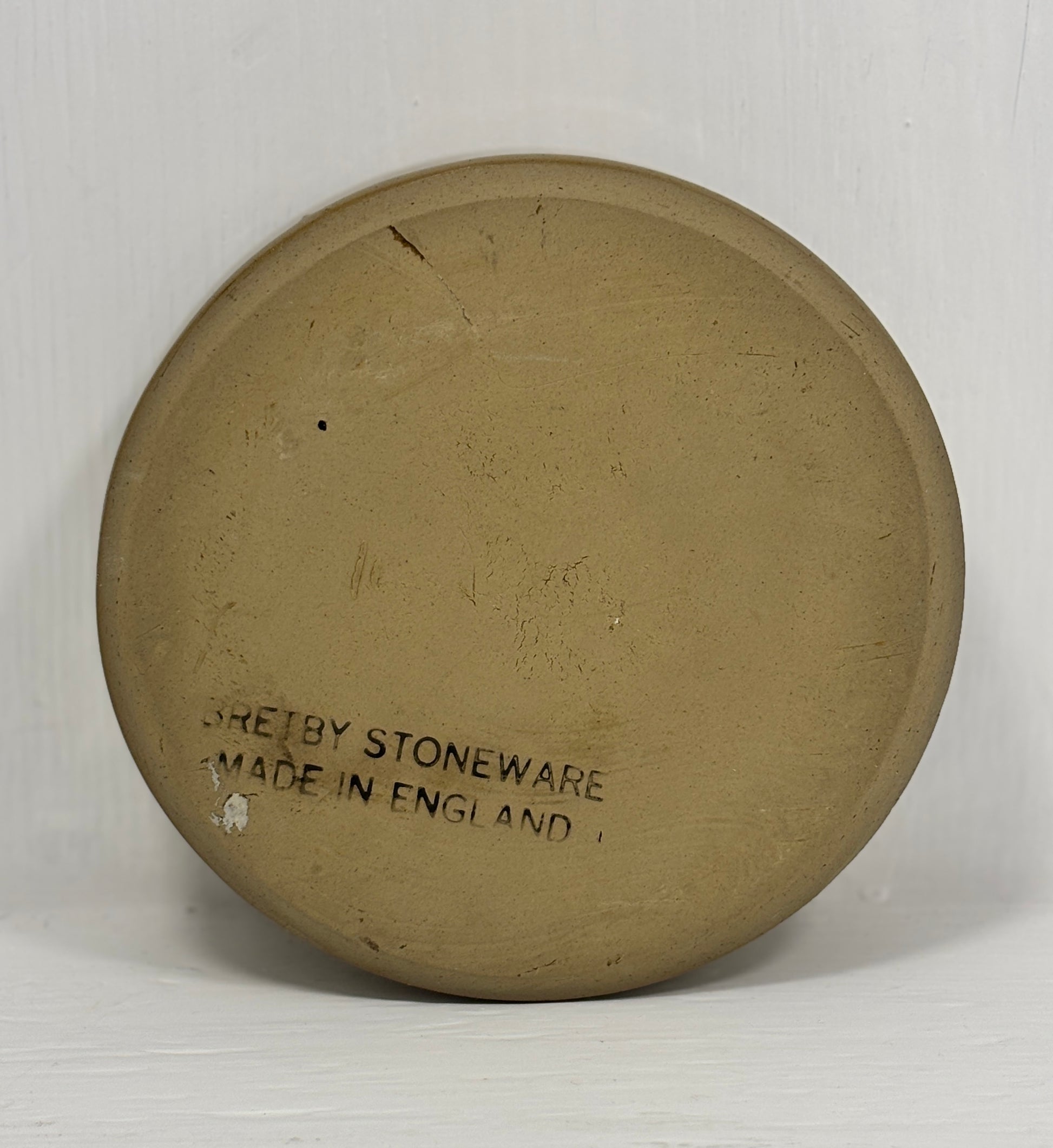 Round stoneware plate with 'Sheffield Stoneware Made in England' text on a white background