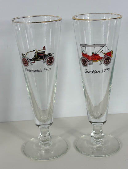 Two glass tumblers with vintage car illustrations and text on a white background