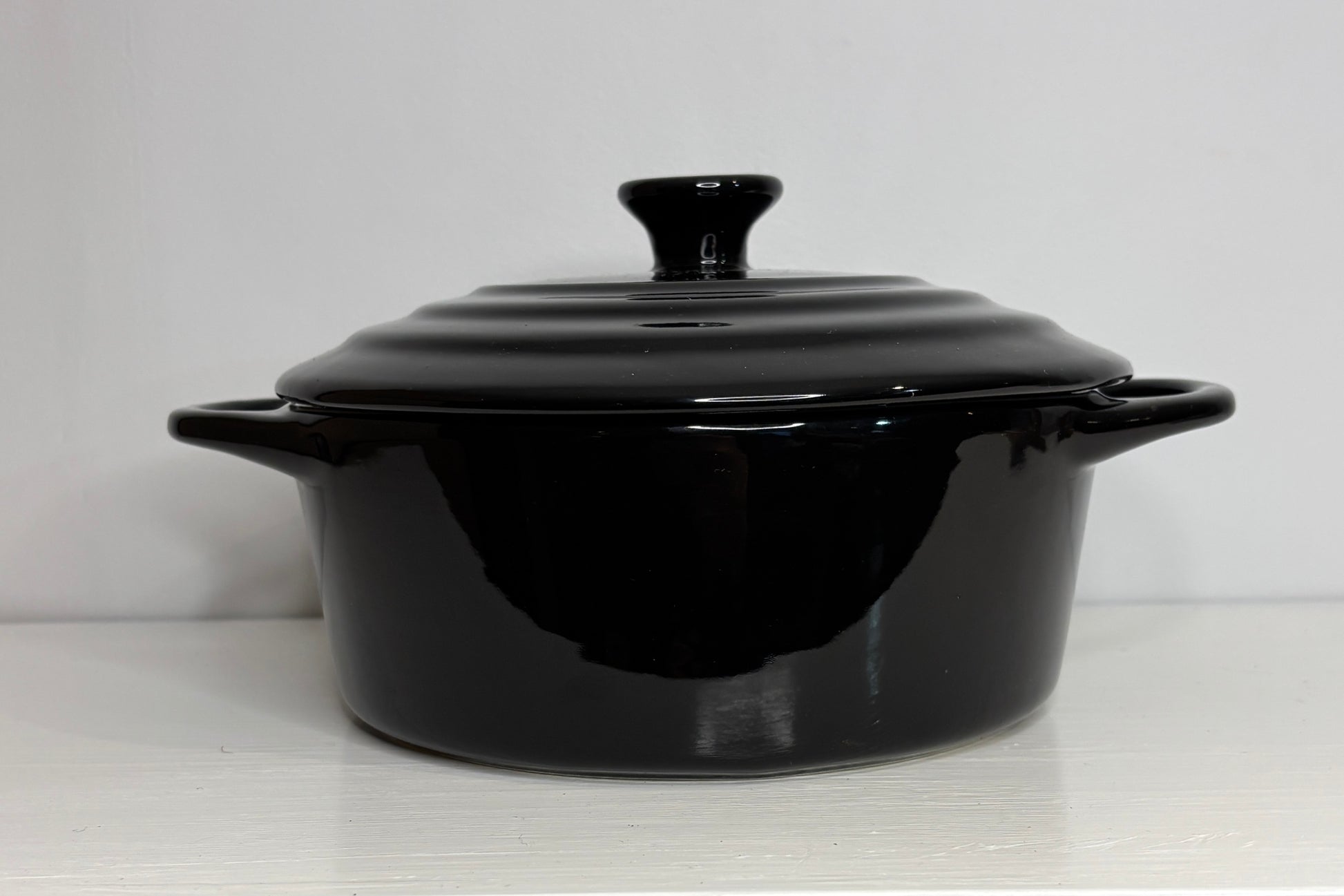 Black ceramic cooking pot with lid on a white background