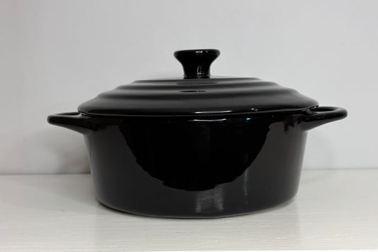 Black ceramic cooking pot with lid on a white background