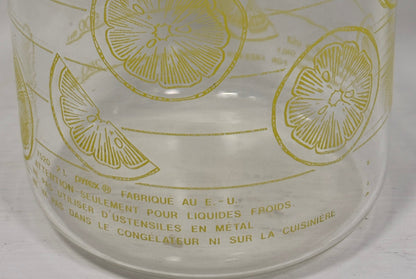 Clear glass bottle with yellow lemon slice pattern on a white background