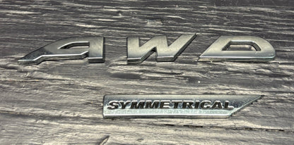 Silver '4WD Symmetrical' badge on a textured metal surface