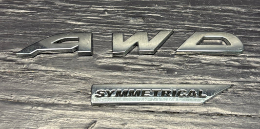 Silver '4WD Symmetrical' badge on a textured metal surface