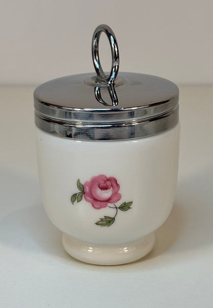 White ceramic jar with pink rose design and silver lid on a white background