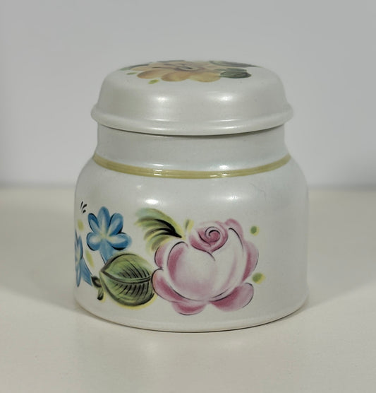 White ceramic sugar bowl with floral designs on a white background