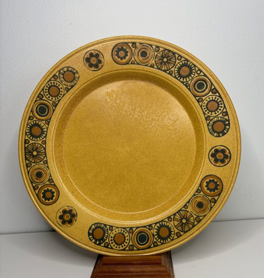 Decorative ceramic plate with brown and black patterns on a white background