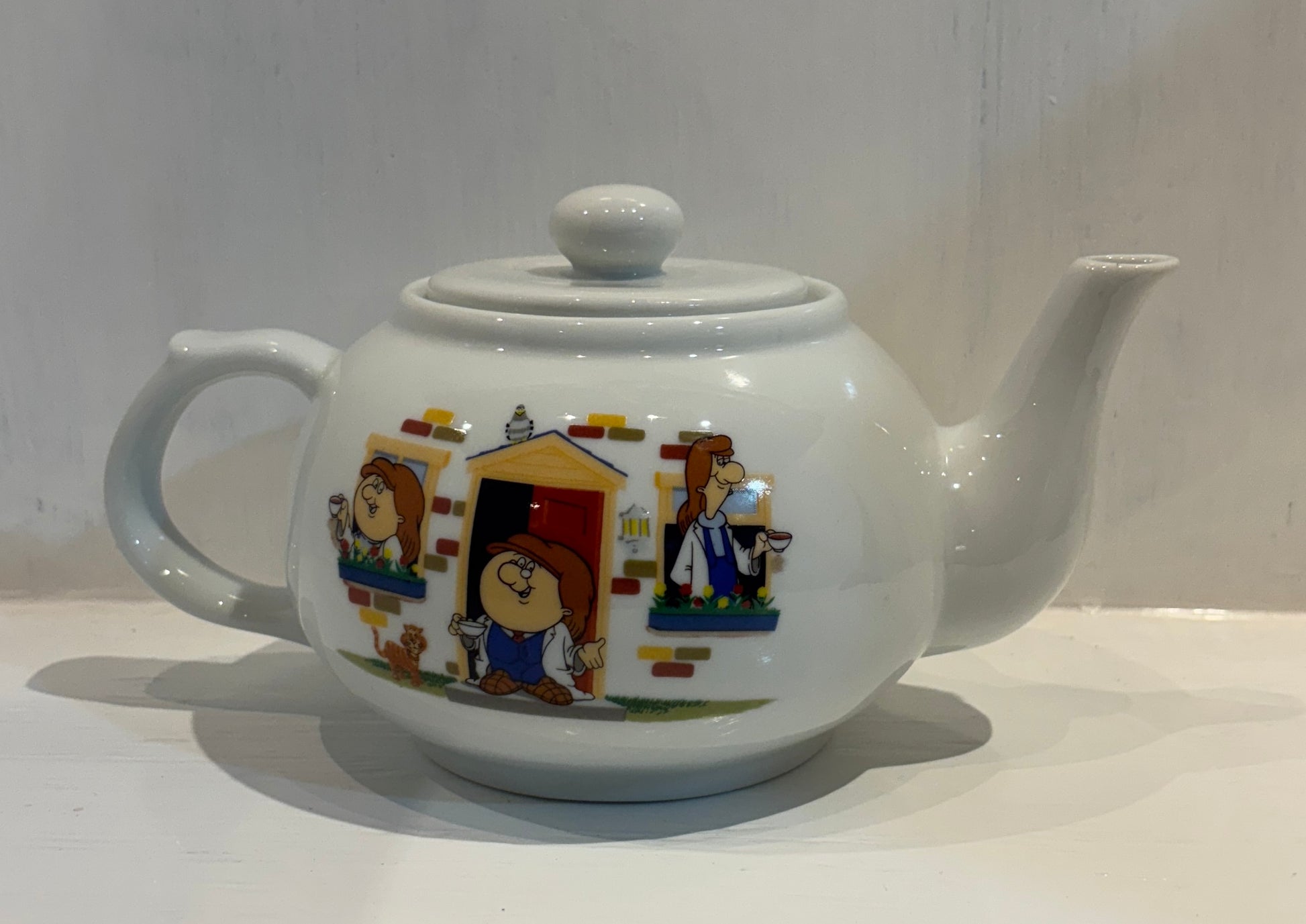 Teapot with cartoon characters on a white background