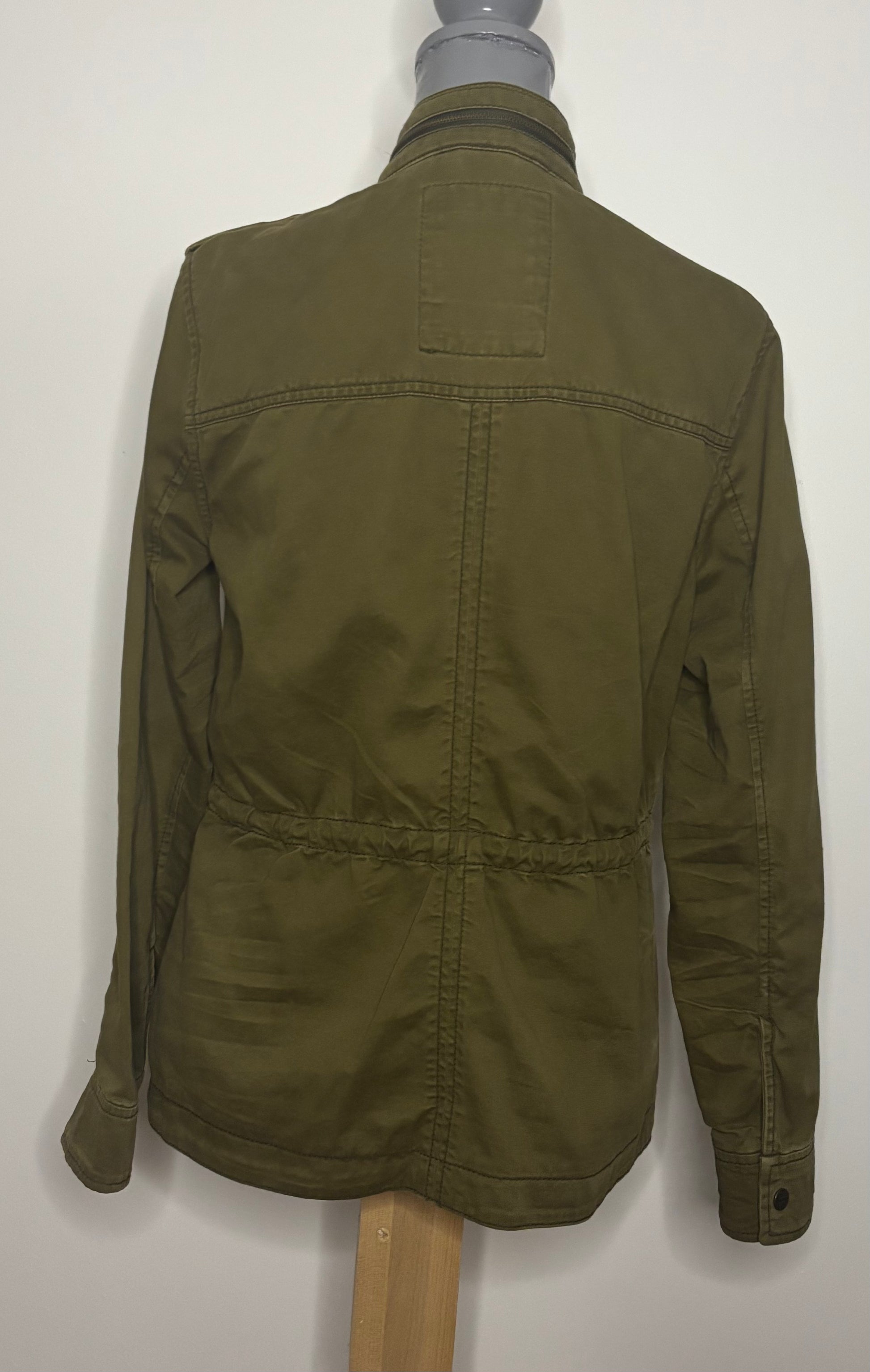 Green jacket on a mannequin against a white background