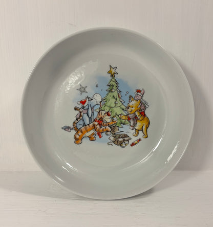 Children's bowl with winie the pooh cartoon characters around a Christmas tree on a white background