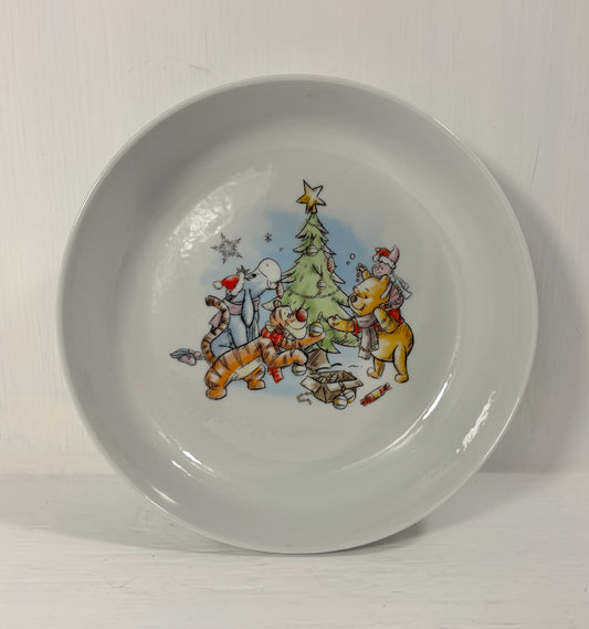 Children's bowl with winie the pooh cartoon characters around a Christmas tree on a white background