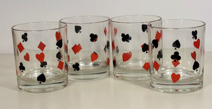 Four clear glasses with playing card suit symbols on a white background