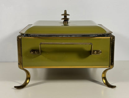 An antique-style lidded serving box or chafing dish with a muted olive green enamel finish and brass-toned metal legs, handle, and trim, set against a plain white background.