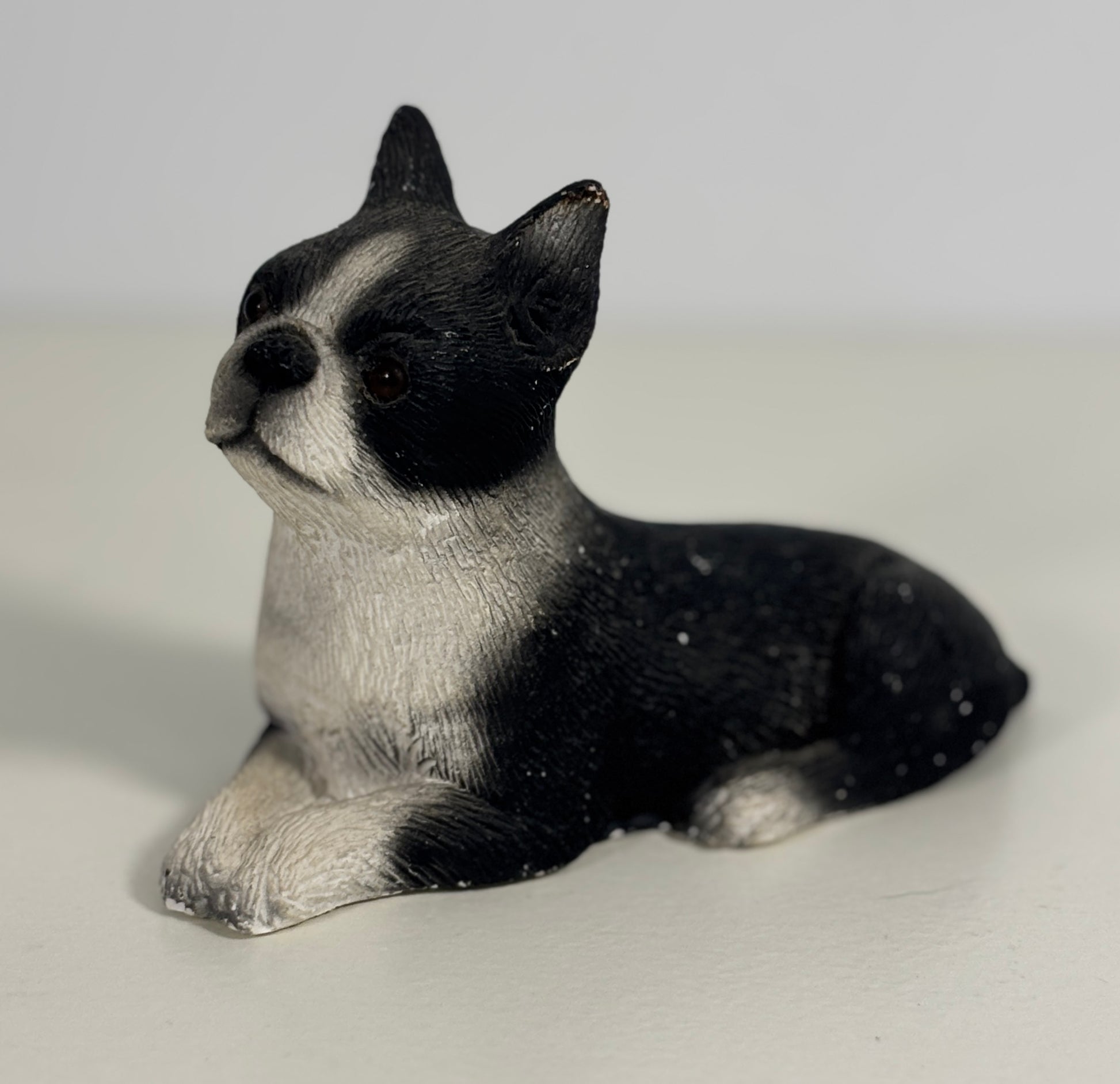 Black and white dog figurine on a light gray background