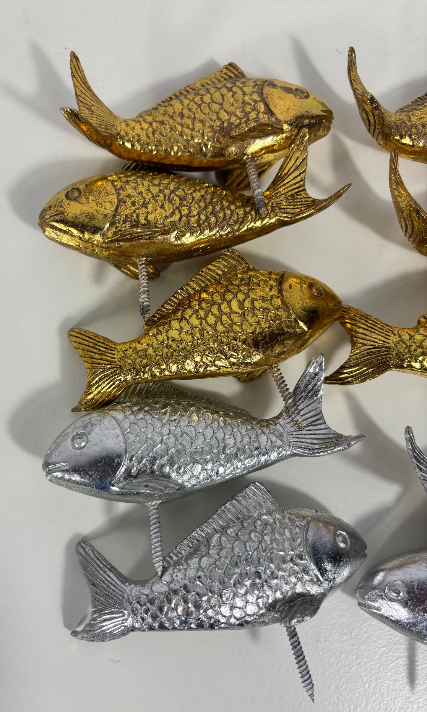 Gold and silver fish-shaped objects on a white background